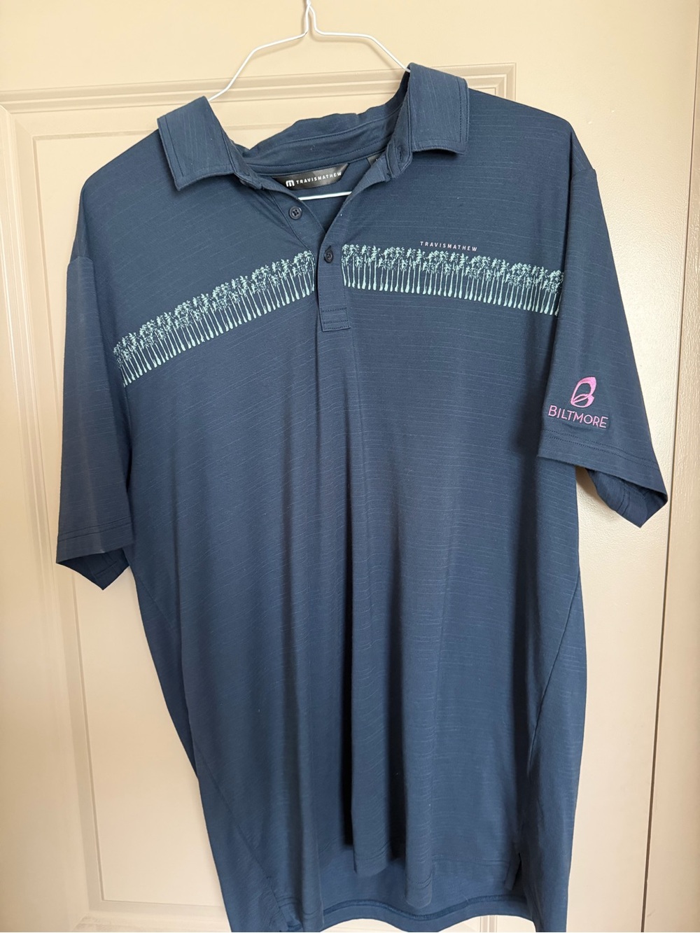 Travis Mathew Men's Blue Polo Shirt with Subtle Chest Stripe Biltmore Logo